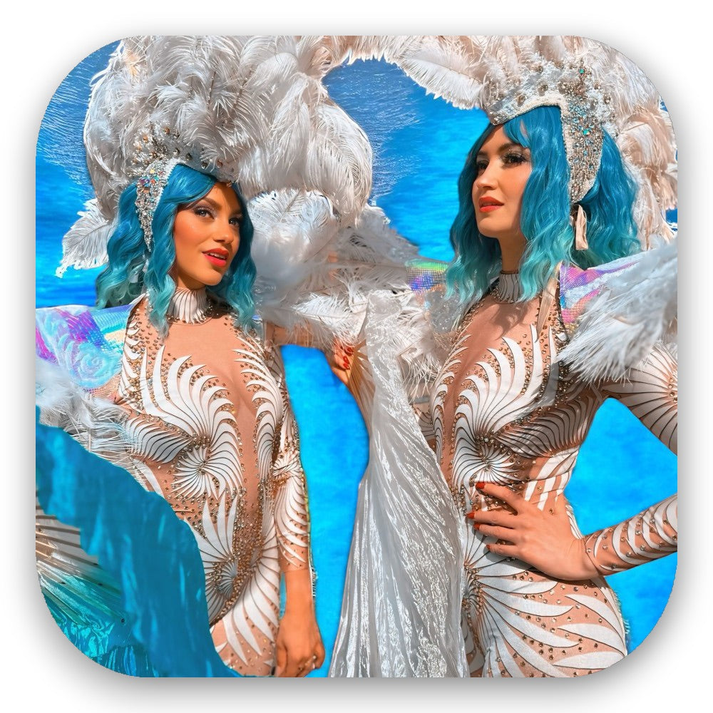 Beach Vibes in schimmernden Bodysuits mit Federn, Strass und türkisfarbenem Haar – paradiesischer Glamour vom GLITTERIMPERIUM von Elli Fatle. Jetzt sommerliche Walking Acts buchen!